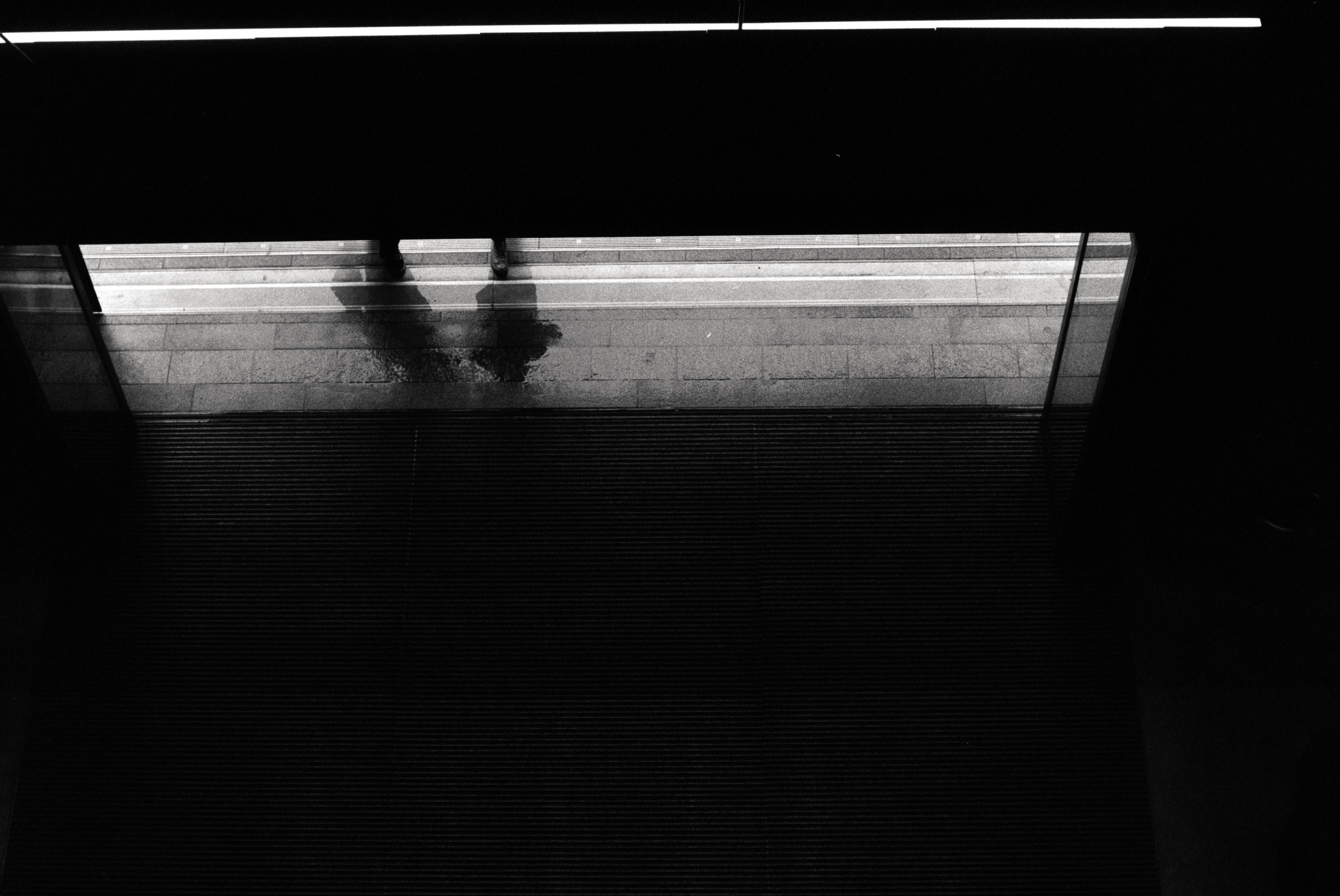 A entrance only showing shadows of two people walking