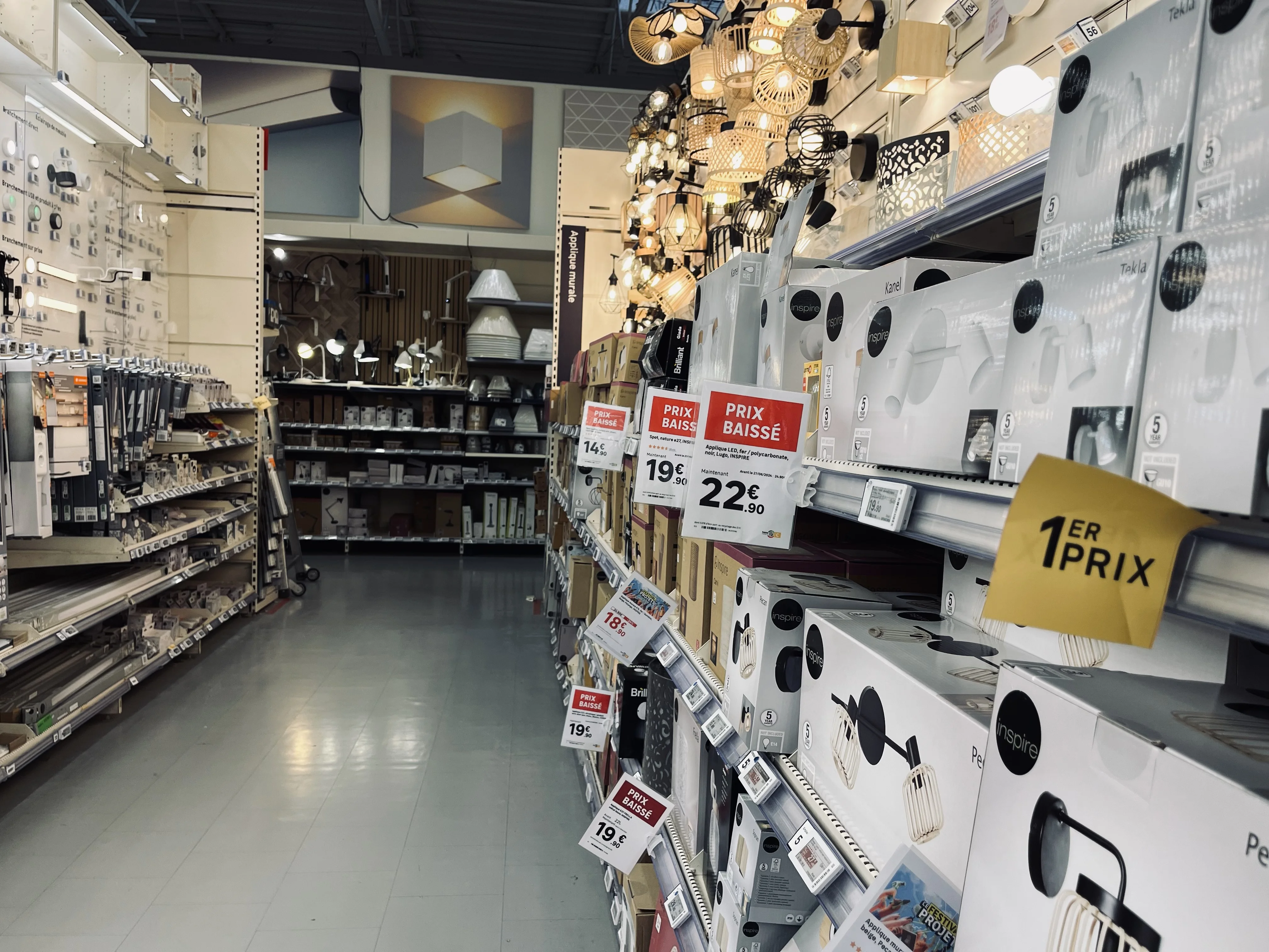 Affiches prix suspendues au-dessus d'une allée de magasin