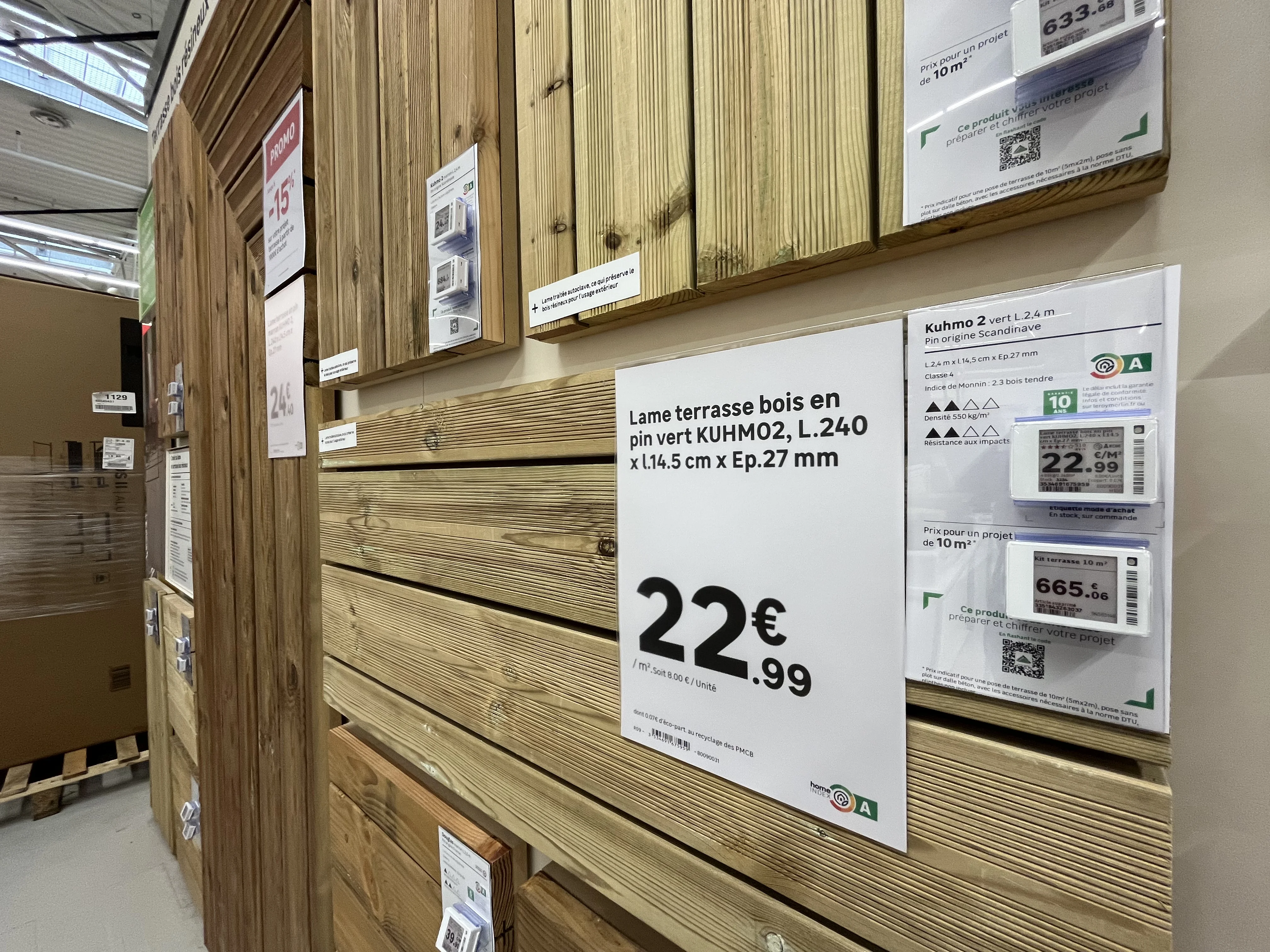 Étiquettes prix papier et étiquette électronique côte à côte sur un rayon de lames de bois