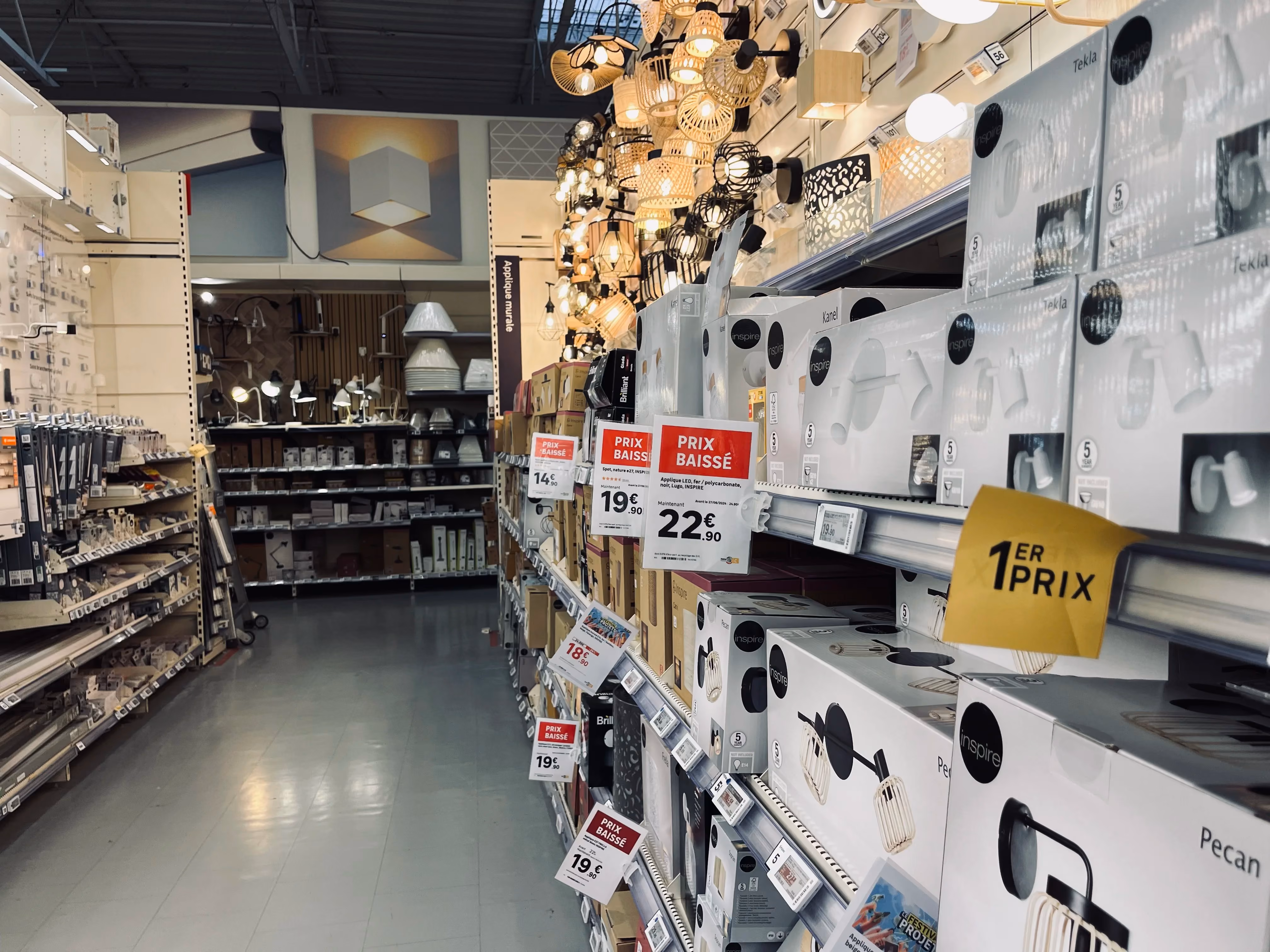Allée de magasin avec affiches et étiquettes de prix suspendues au-dessus des rayons