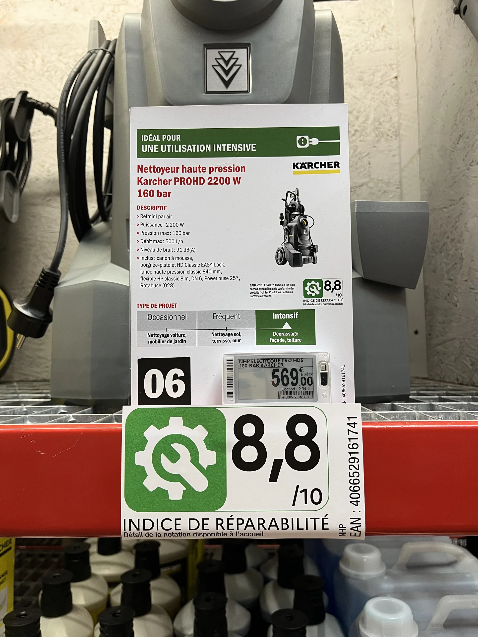 Fiche produit papier d'un nettoyeur haute pression avec indice de réparabilité, au-dessus d'une étiquette électronique