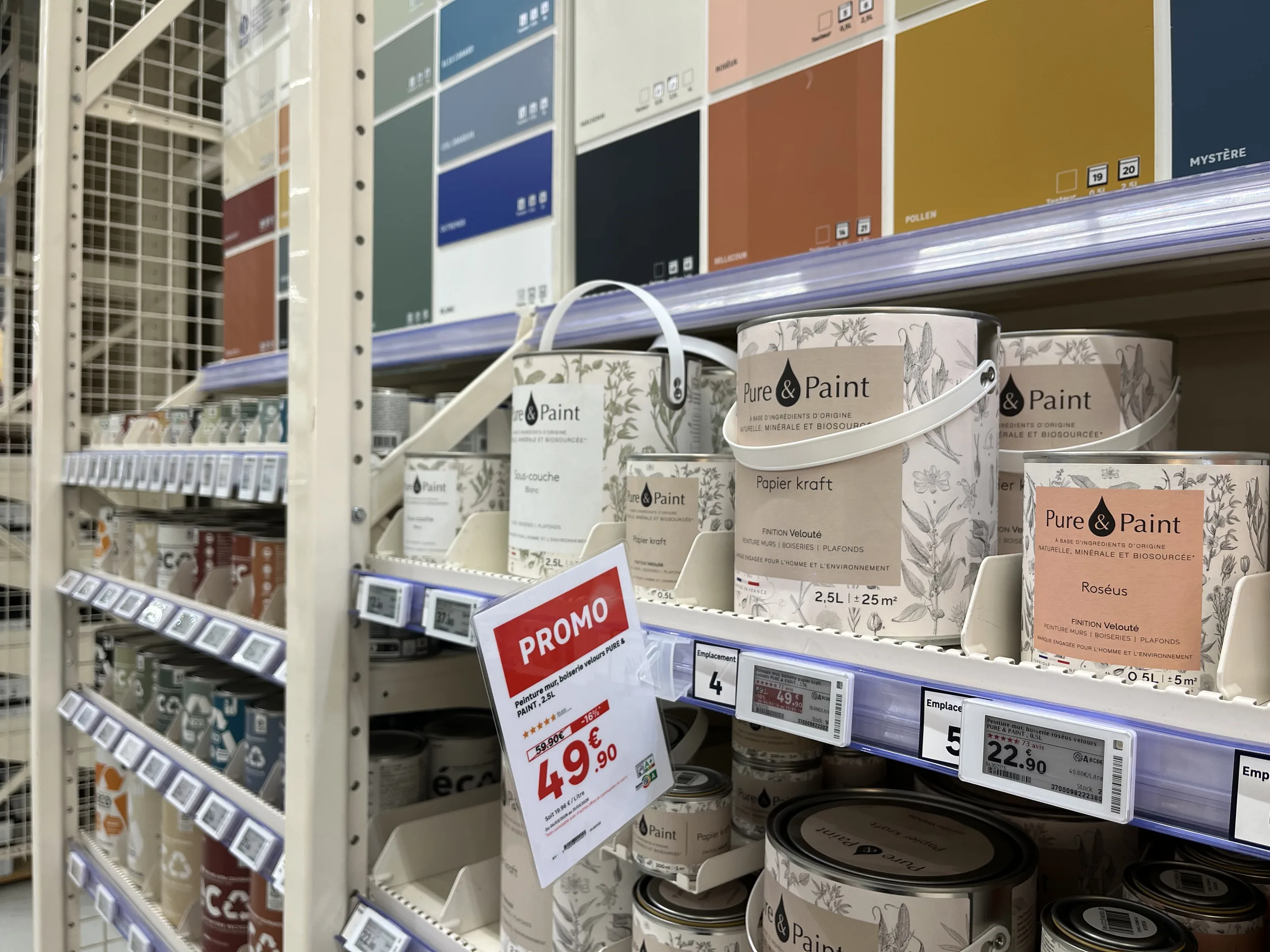 Rayon peinture avec une affiche promotionnelle papier suspendue au-dessus d'étiquettes électroniques de gondole