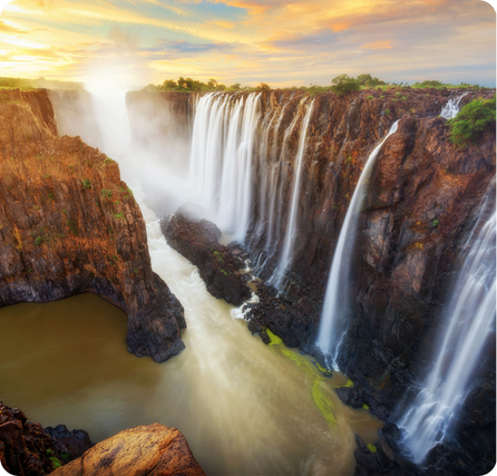Victoria Falls with a wide curtain of water crashing into the gorge below