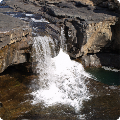 Mitchell Falls showing tiered red rock waterfalls in a remote landscape