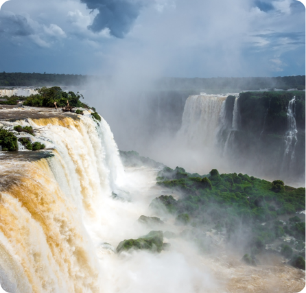 Iguazú Falls with wide cascading waterfalls surrounded by dense green rainforest