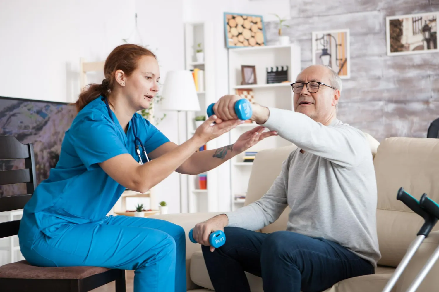 Physical therapist assisting senior patient with strength and mobility exercises during in-home rehabilitation therapy session