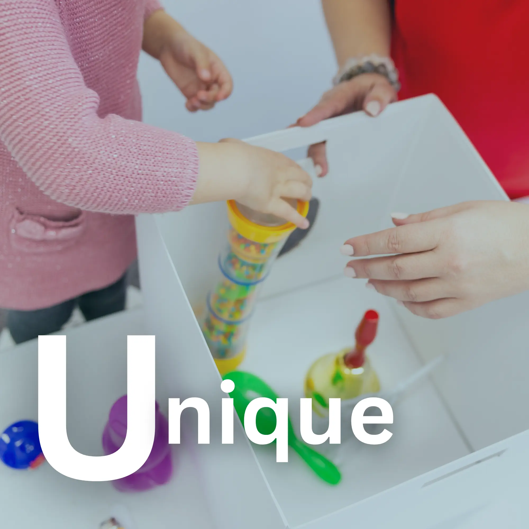 Child and adult hands interacting with colorful toys inside a white box with the word Unique.
