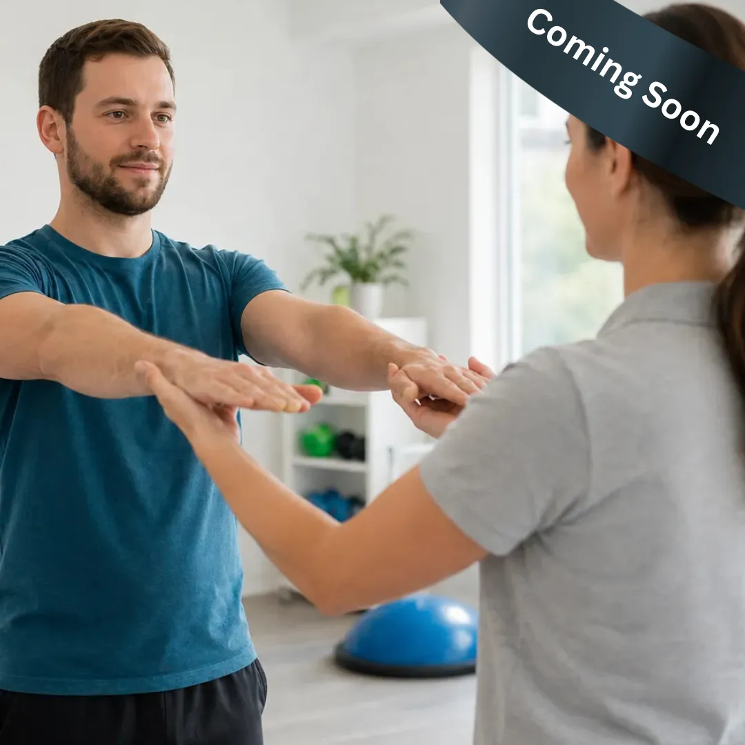 Man and woman facing each other holding hands, in a bright room with a blue exercise ball.