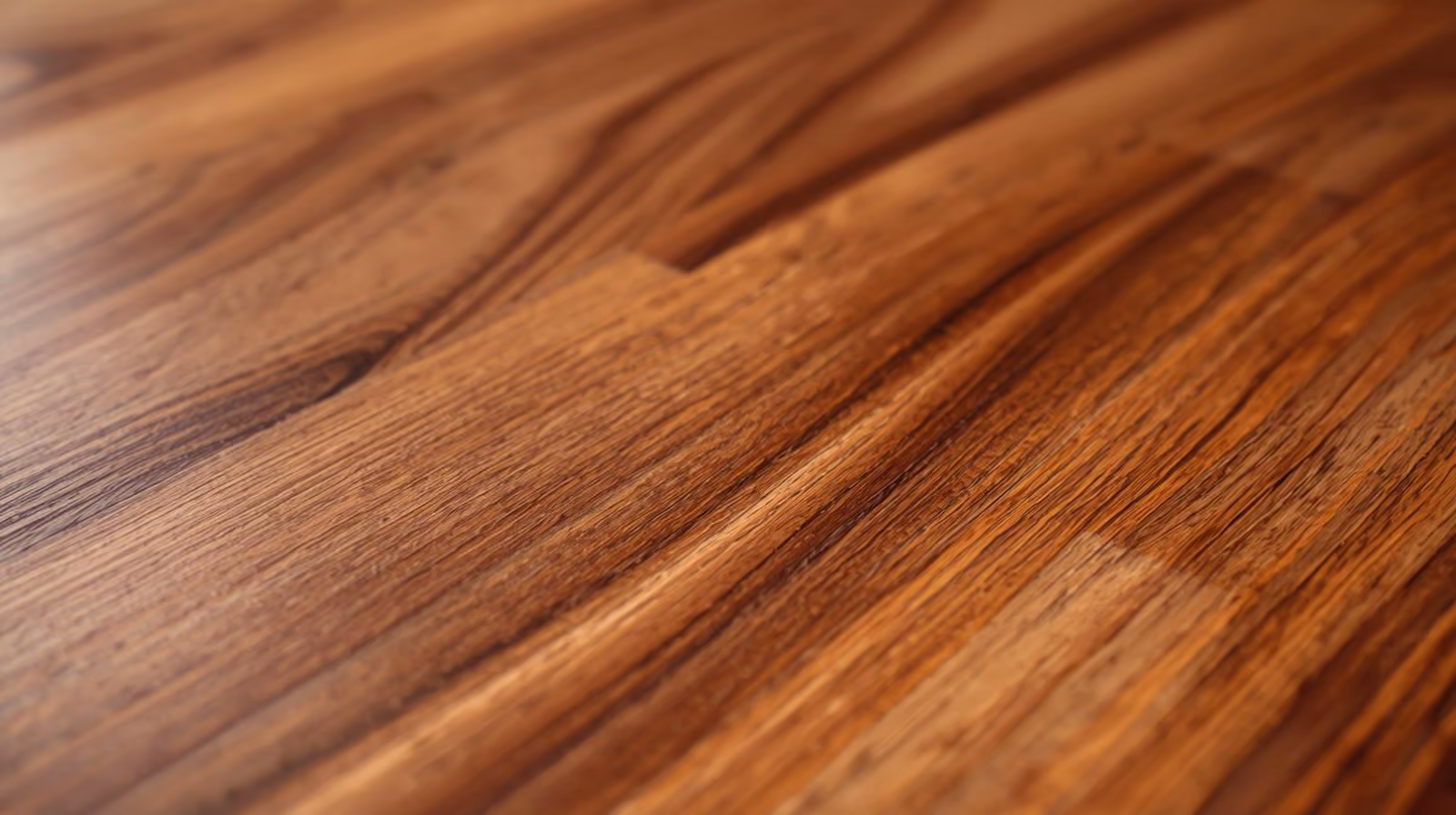 Close-up of polished hardwood flooring with natural wood grain patterns and warm tones.