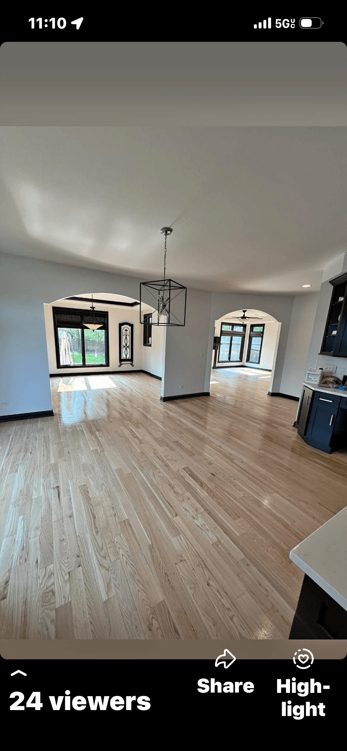 Man operating floor polishing machine on hardwood floor in kitchen with brown cabinets.