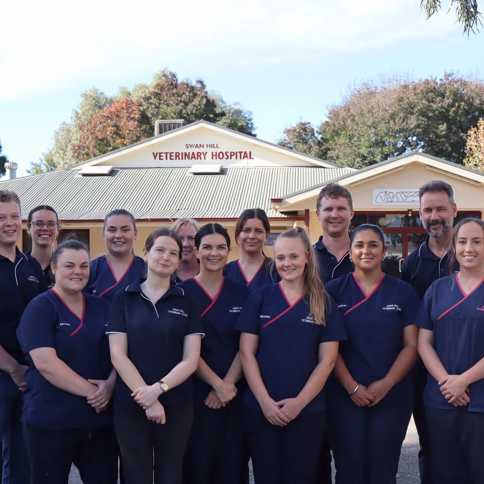 Group of veterinary staff standing and smiling outside Swan Hill Veterinary Hospital.