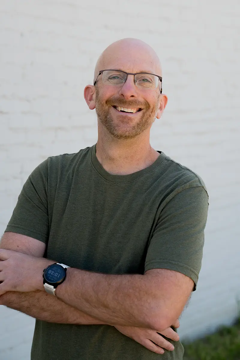 Matthew Penner smiling with his arms crossed