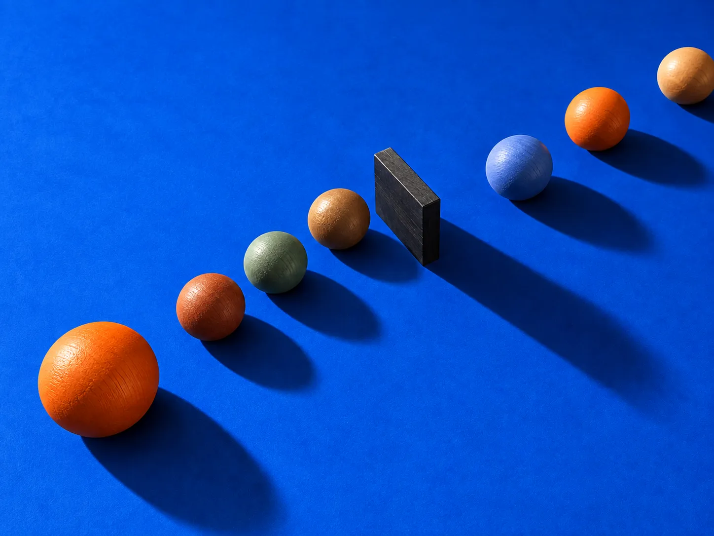Colorful wooden spheres form a queue interrupted by a dark block.