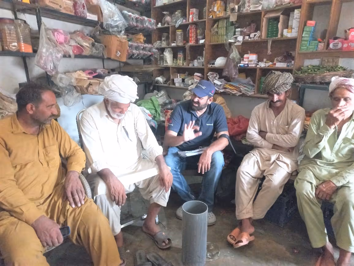 sitting with local farmers to teach them