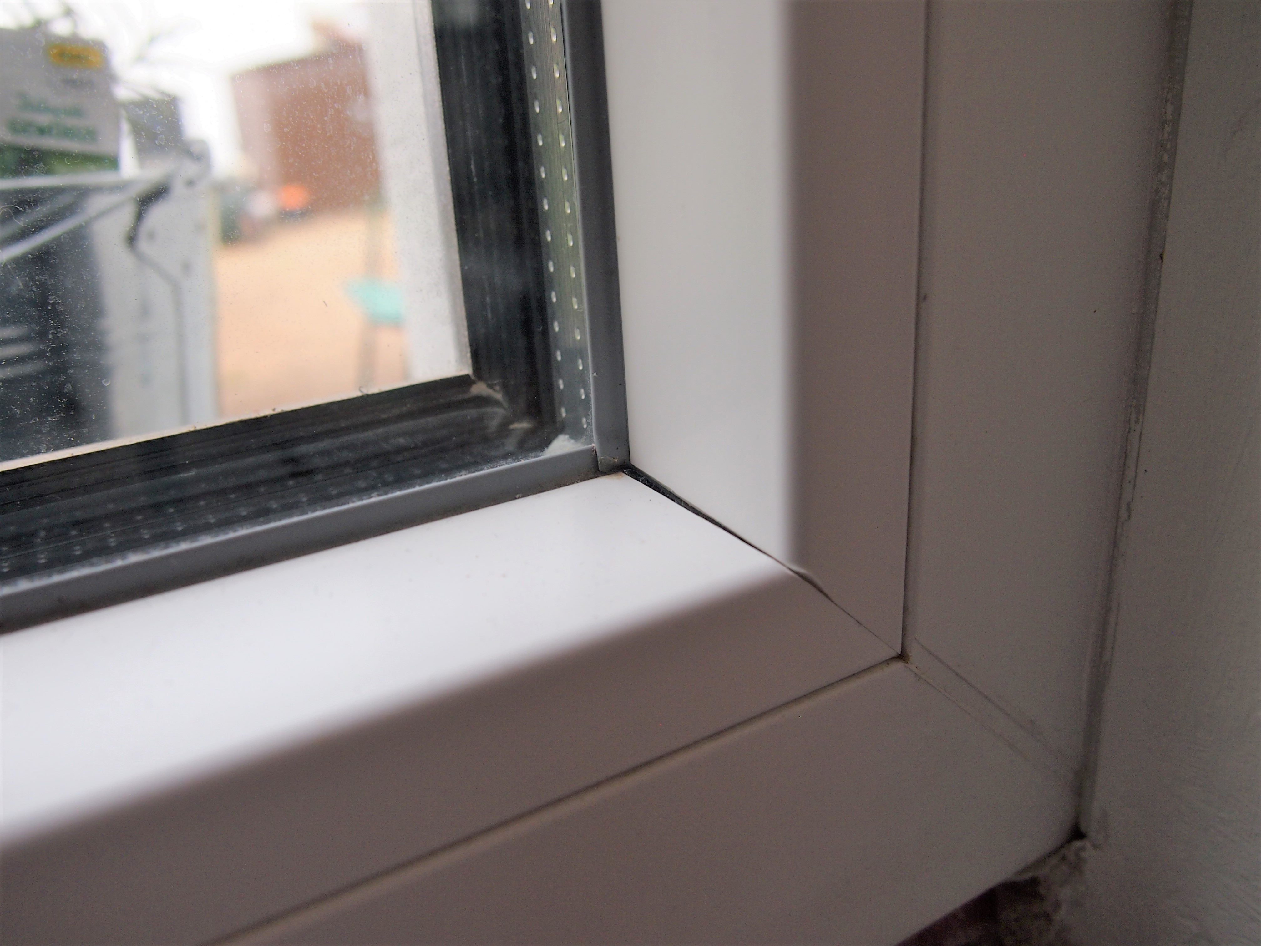 Schlampig geschnittene Glasleisten bei einem Fenster