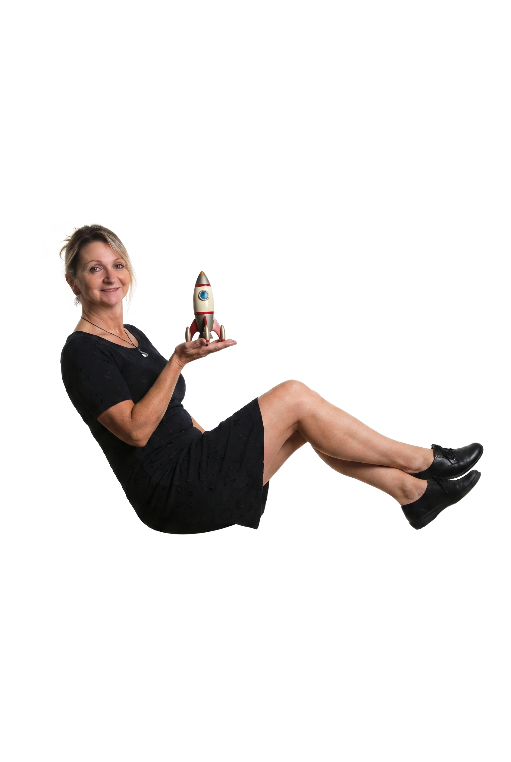 Frau im schwarzen Kleid hält ein kleines Modell einer Rakete in ihrer rechten Hand.