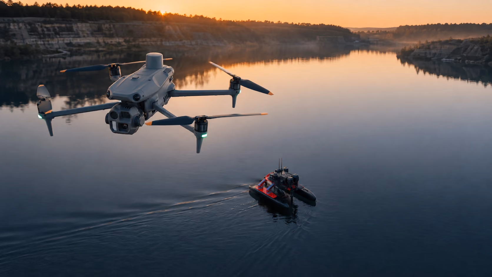 Drohne fliegt über ruhigem Gewässer bei Sonnenuntergang mit ferngesteuertem Boot darunter.
