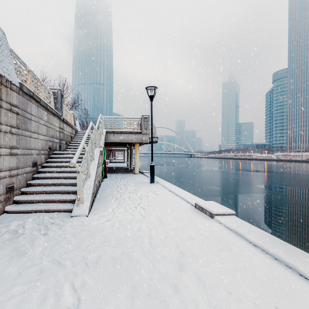 Verschneite Uferpromenade mit Hochhäusern in moderner Stadt