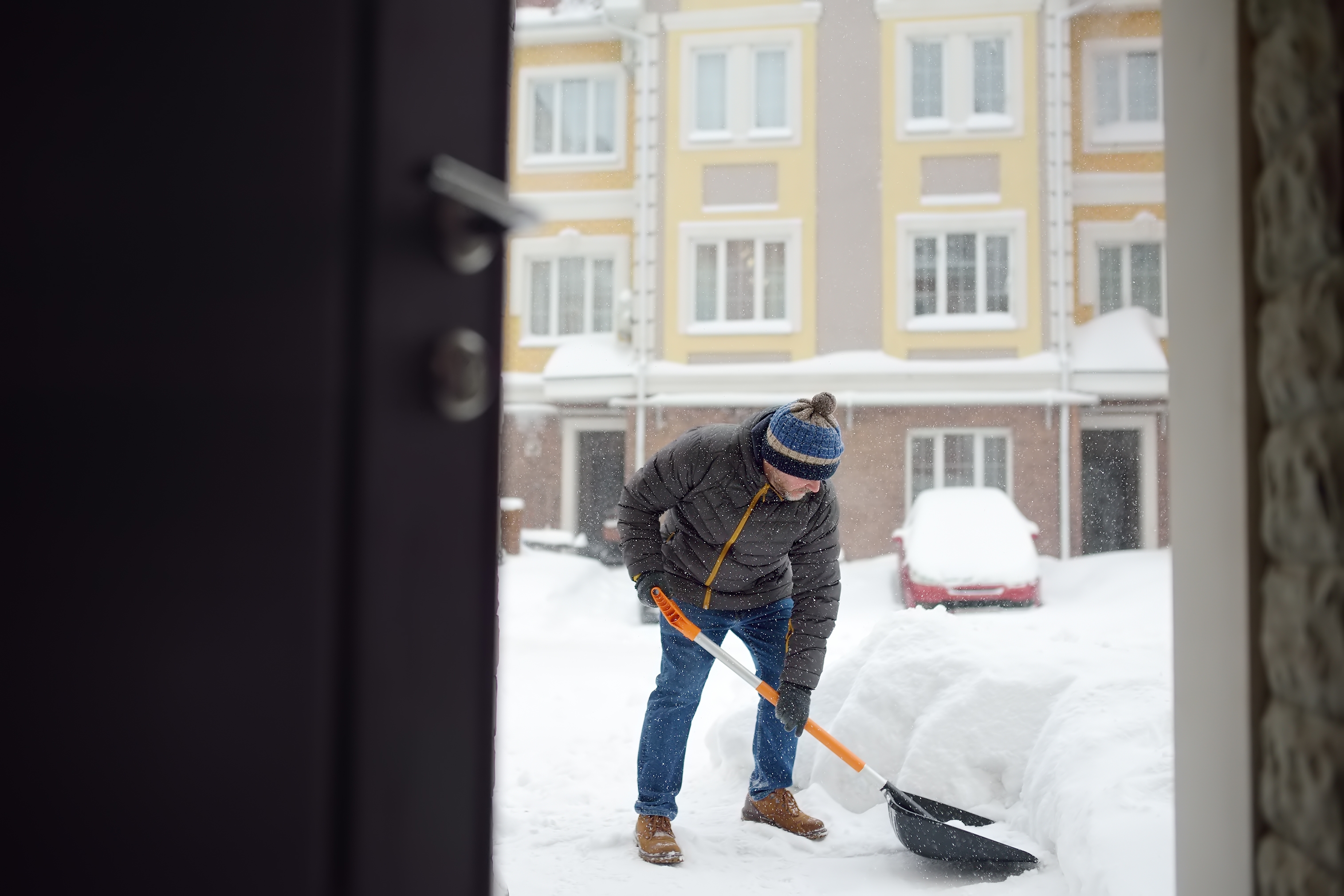 Schneeräumung im Winterdienst vor einem Mehrfamilienhaus