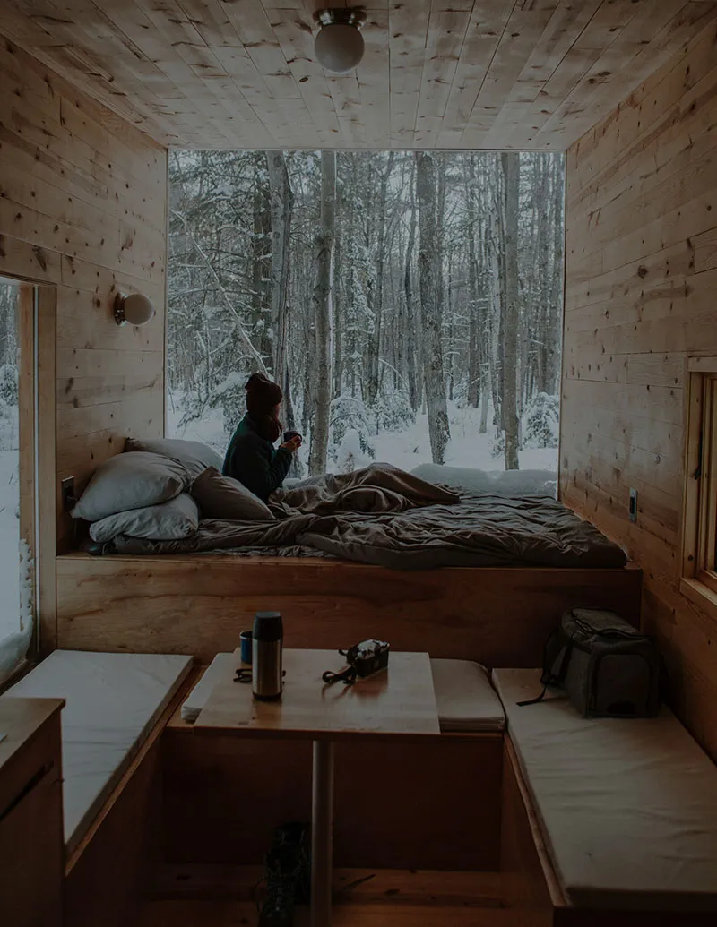 Cosy cabin interior overlooking a snow-covered forest