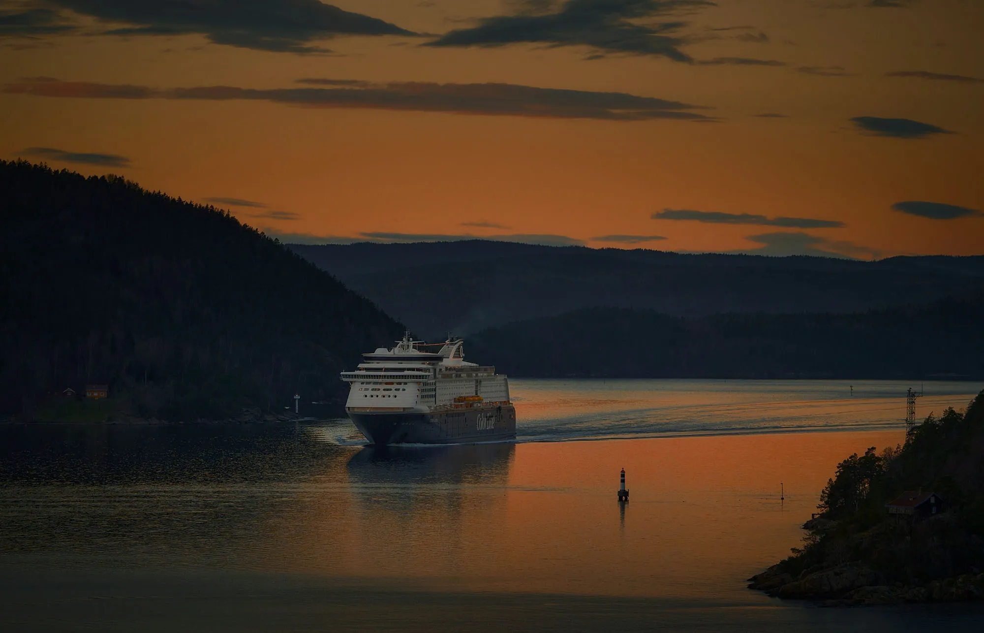 Boat crossing calm water at sunset