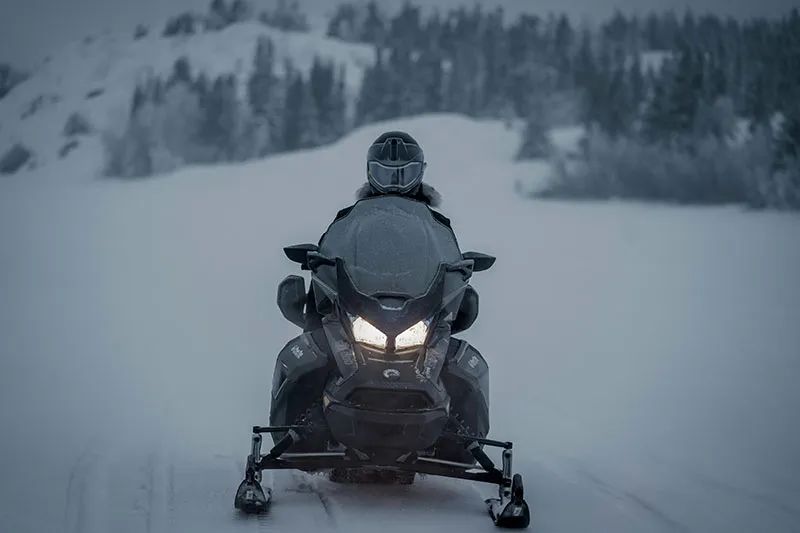 Snowmobile rider crossing a snowy Lapland landscape