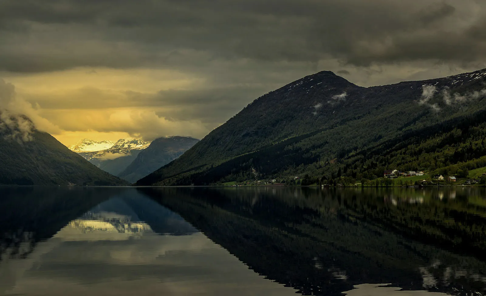 Mountain valley reflected in a still Norwegian fjord