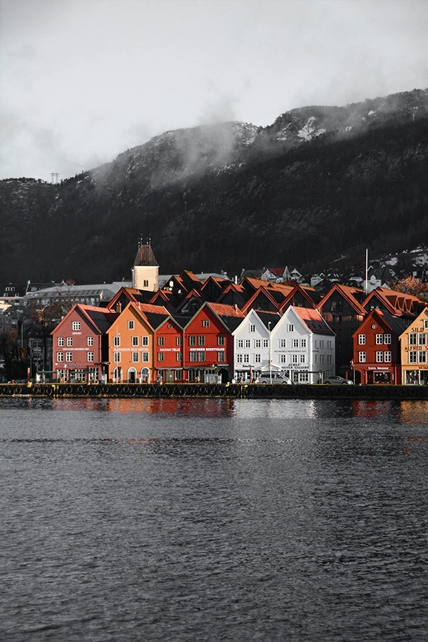 Colourful waterfront houses beneath mountains in Bergen