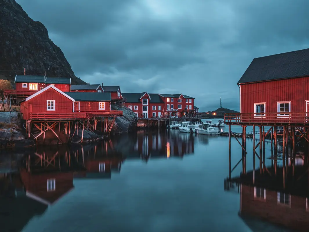 Red fishing cabins beside a Norwegian fjord