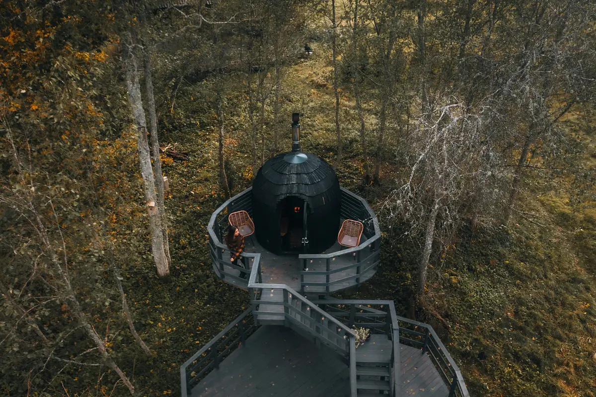 Dome-shaped sauna on a wooden deck in an autumn forest