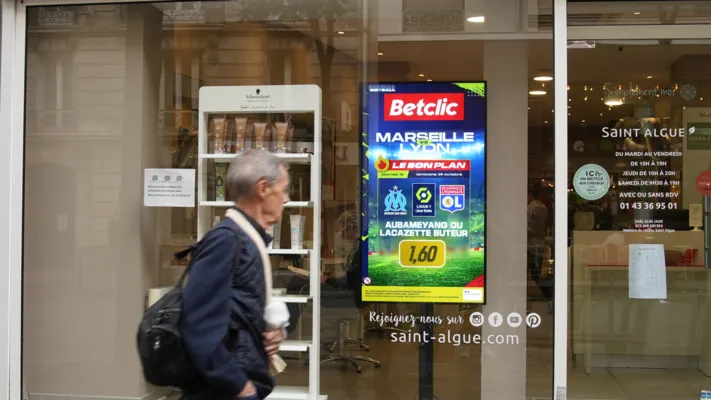 Écran d'affichage numérique en ville présentant une publicité pour une application mobile augmentant sa visibilité auprès des passants.