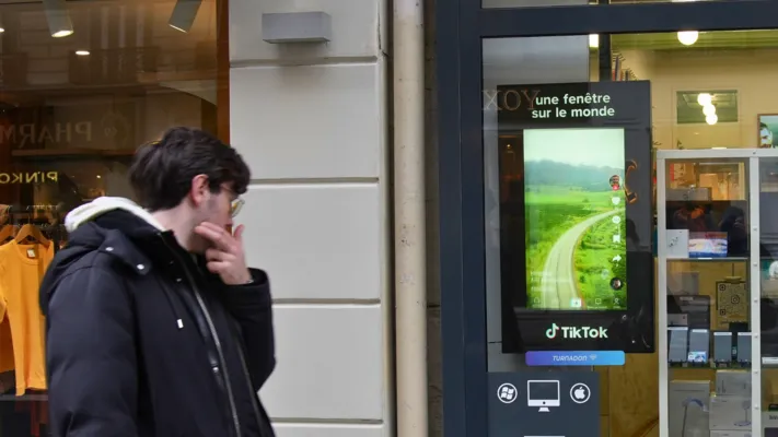 Ecran d'affichage situé dans une zone stratégique diffusant une campagne pour une application mobile.