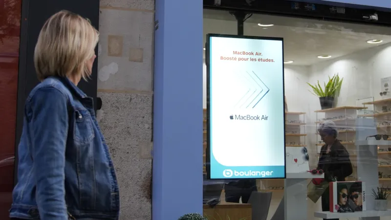 Passants captivés par une publicité immersive diffusée sur un écran DOOH illustrant l’impact émotionnel du contenu visuel.
