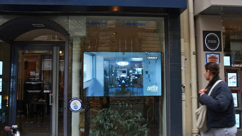Passants attirés par un écran vitrine offrant une expérience immersive.