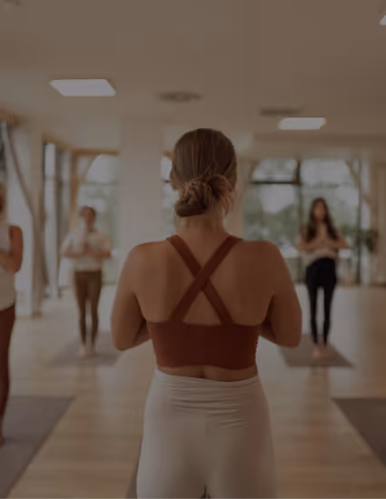 Yogalehrerin leitet Gruppe im Studio von Nalu Yoga Rostock – Link zu Events und Workshops