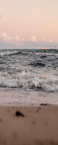 Ruhiger Ostseestrand mit sanften Wellen bei Sonnenuntergang als Sinnbild für die Philosophie von Nalu Yoga Rostock