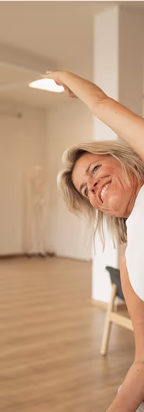 Frau lacht beim seitlichen Strecken in einer 1:1 Yogastunde im Studio von Nalu Yoga Rostock