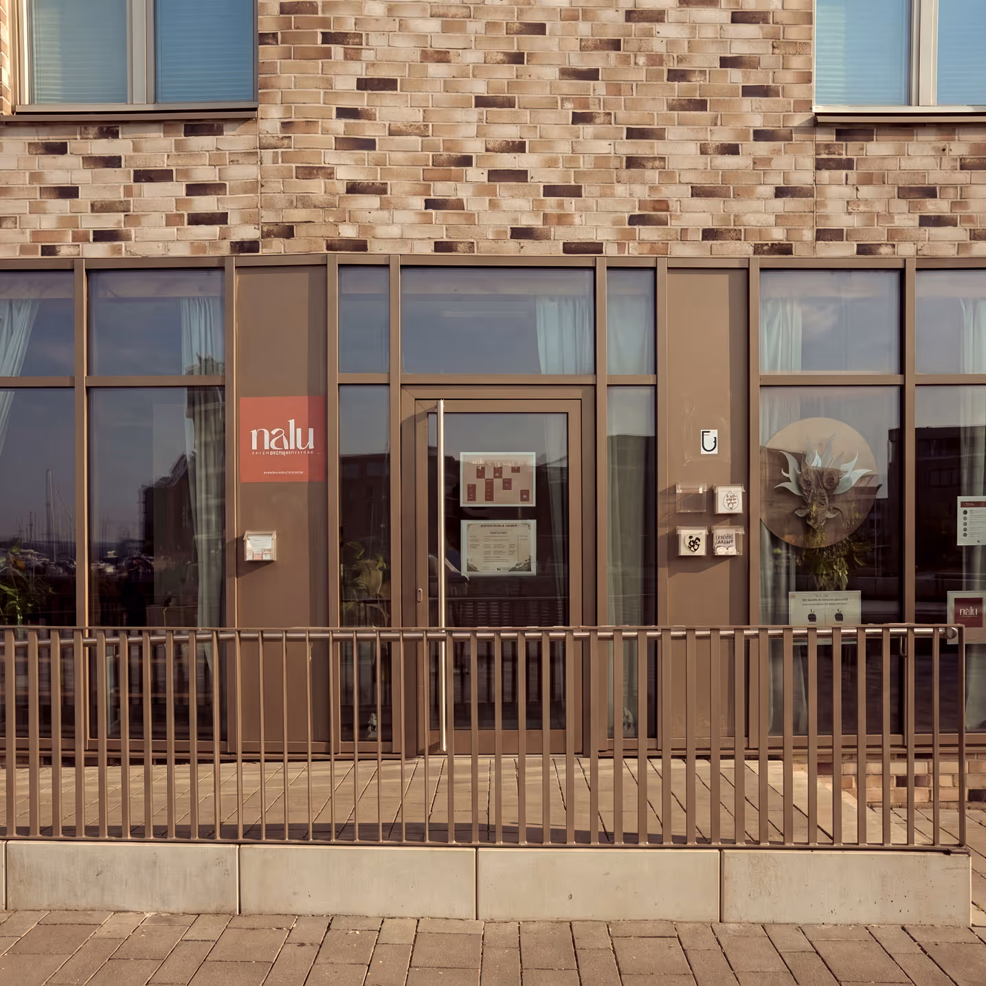 Außenansicht des Nalu Yoga Studios in Rostock mit Eingangsbereich und Nalu-Schriftzug direkt am Warnowufer