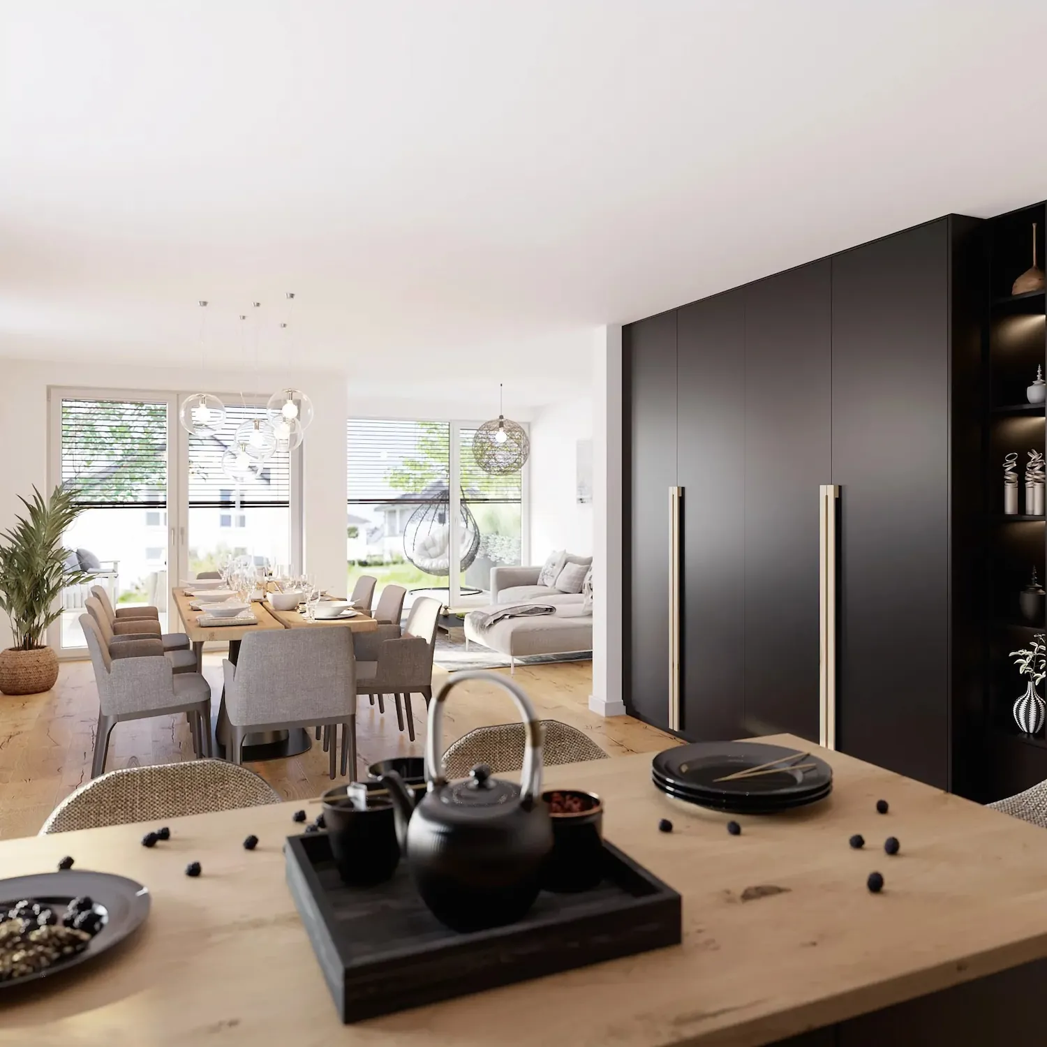 Heller Essbereich mit Holztisch, grauen Stühlen, schwarzer Küchenschrankwand und Sicht auf Wohnzimmer.