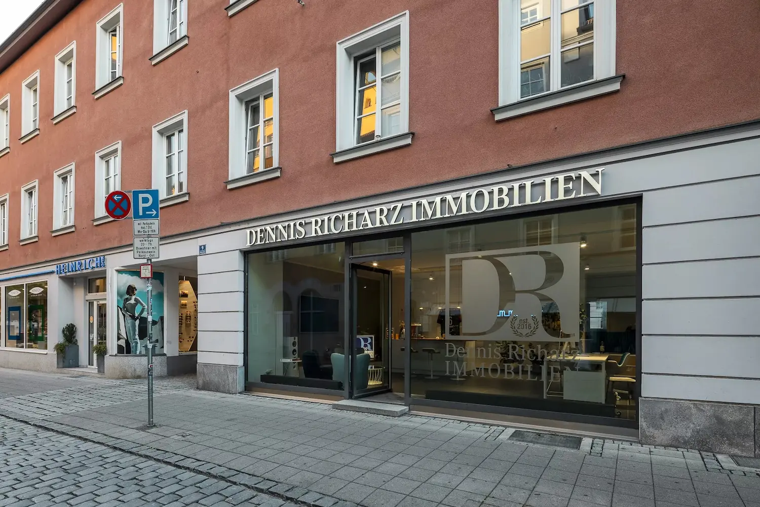 Straßenansicht des Bürogebäudes von Dennis Richarz Immobilien mit großem Schaufenster und Eingangsbereich.