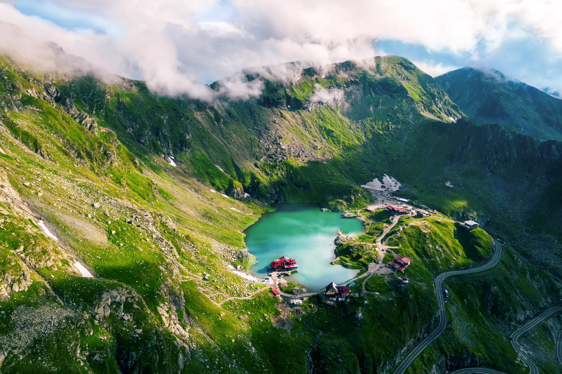 Vedere aeriană asupra căldării glaciare Bâlea, cu lacul, cabanele și serpentinele Transfăgărășanului