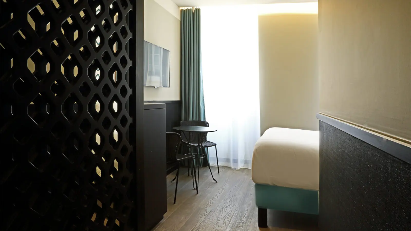 Chambre de l'Hôtel La Joliette : claustra ajouré et grand lit