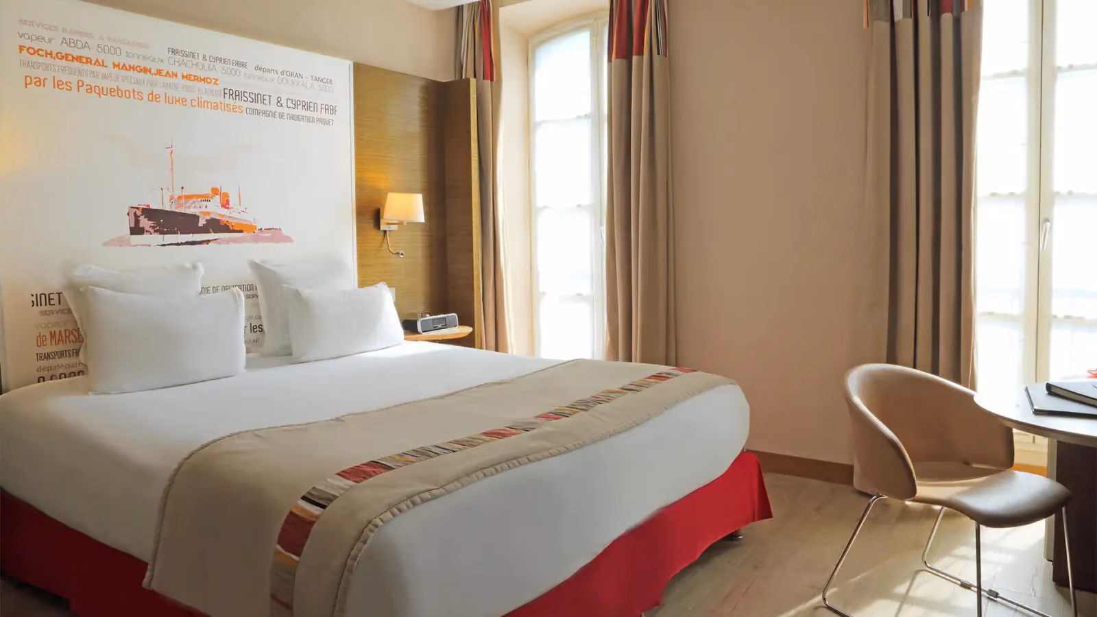 Chambre Supérieure : grand lit, affiche de paquebot et fauteuil