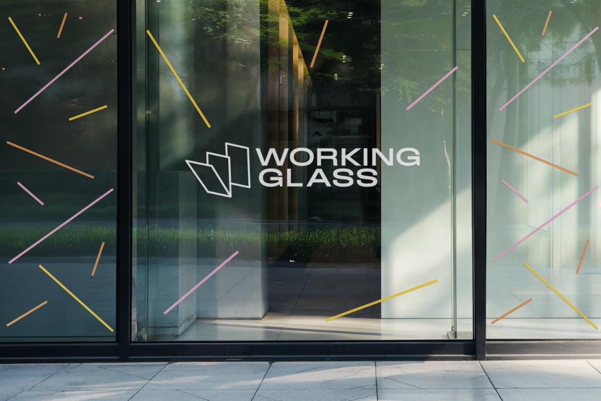 Glass storefront with decorative colored lines and a white logo reading 'WORKING GLASS'.