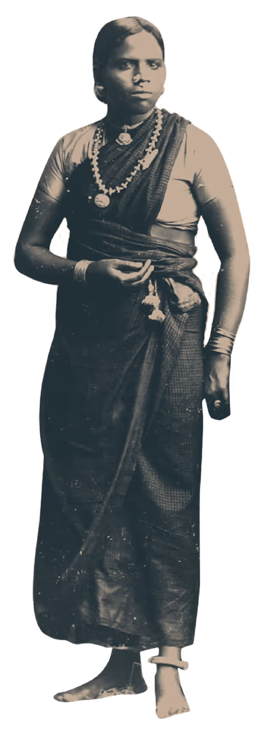 Black and white photo of a woman in traditional Indian sari and jewelry standing barefoot.