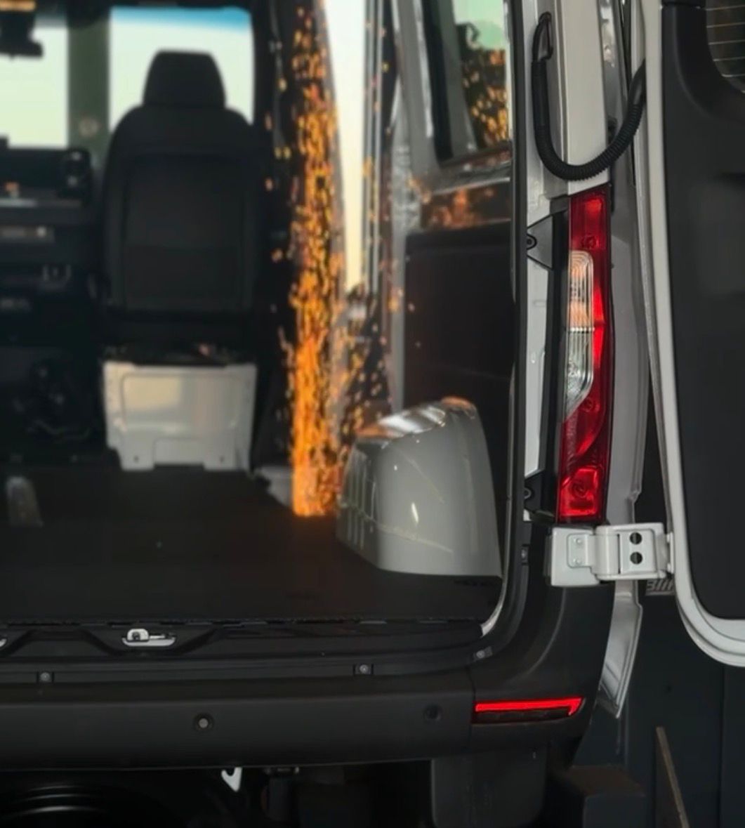 Open back of a white van with visible sparks inside near the driver's seat.