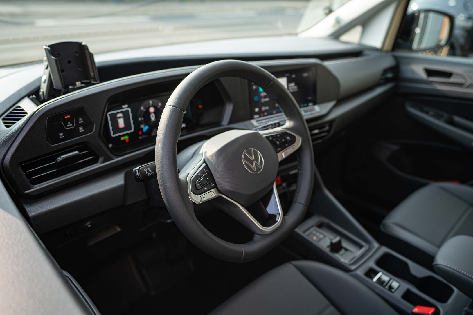 Interior of a Volkswagen car showing the steering wheel, dashboard, and driver's seat.