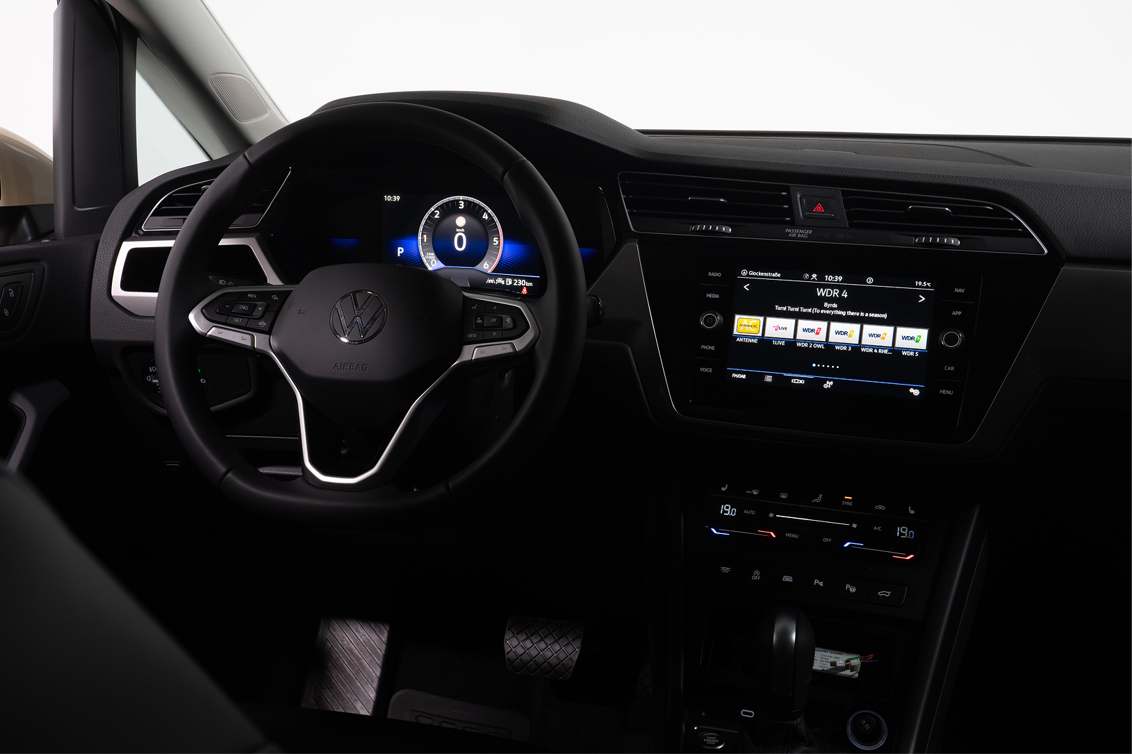 Interior view of a Volkswagen dashboard with steering wheel, digital speedometer, and infotainment screen.