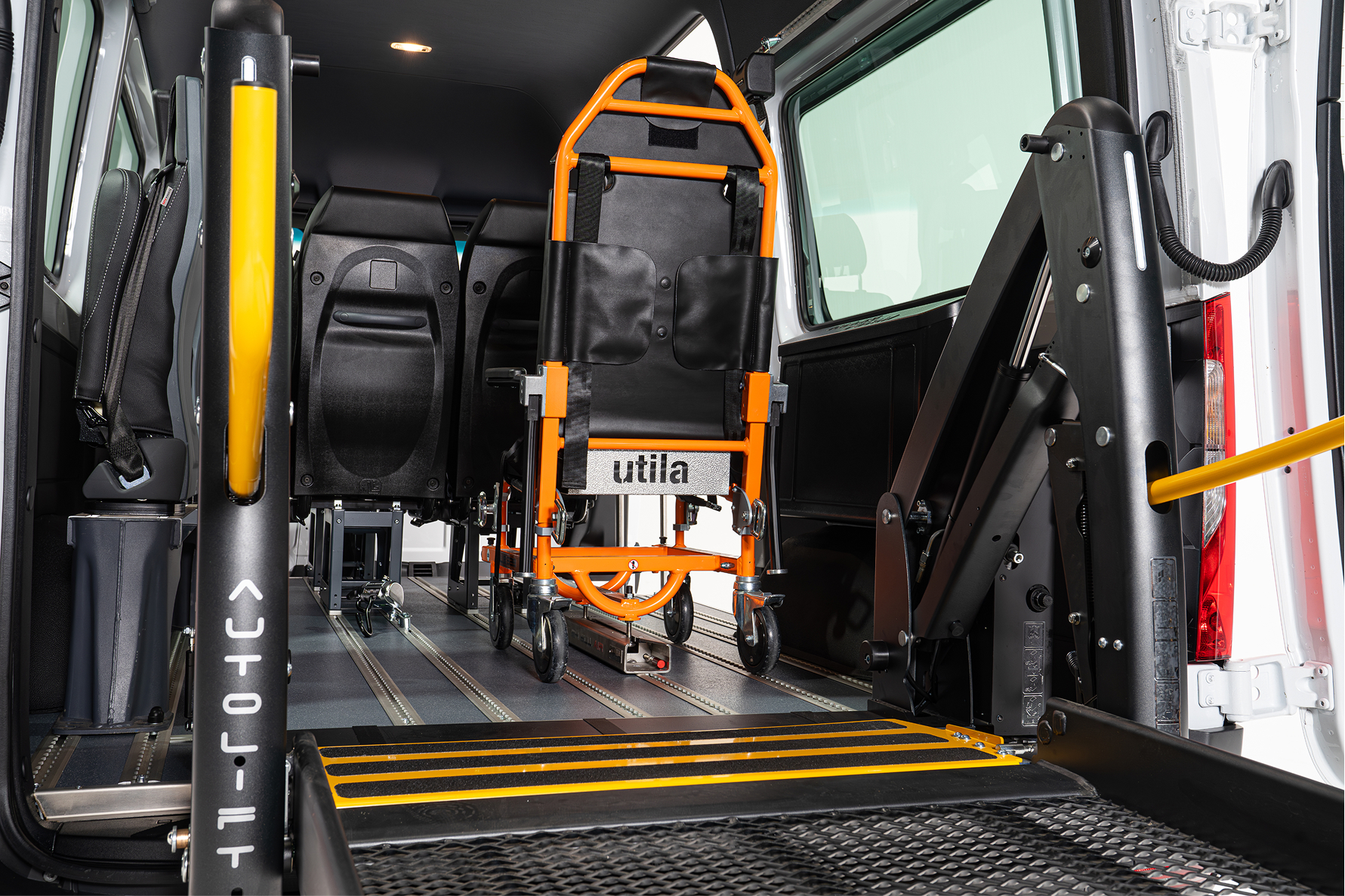 Interior of accessible van showing wheelchair lift platform and orange emergency evacuation chair.