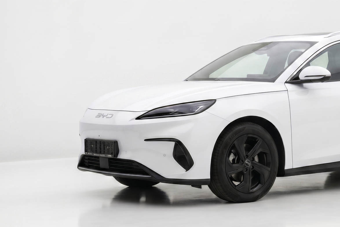 Close-up of the front side of a white BYD electric car with black wheels on a white background.